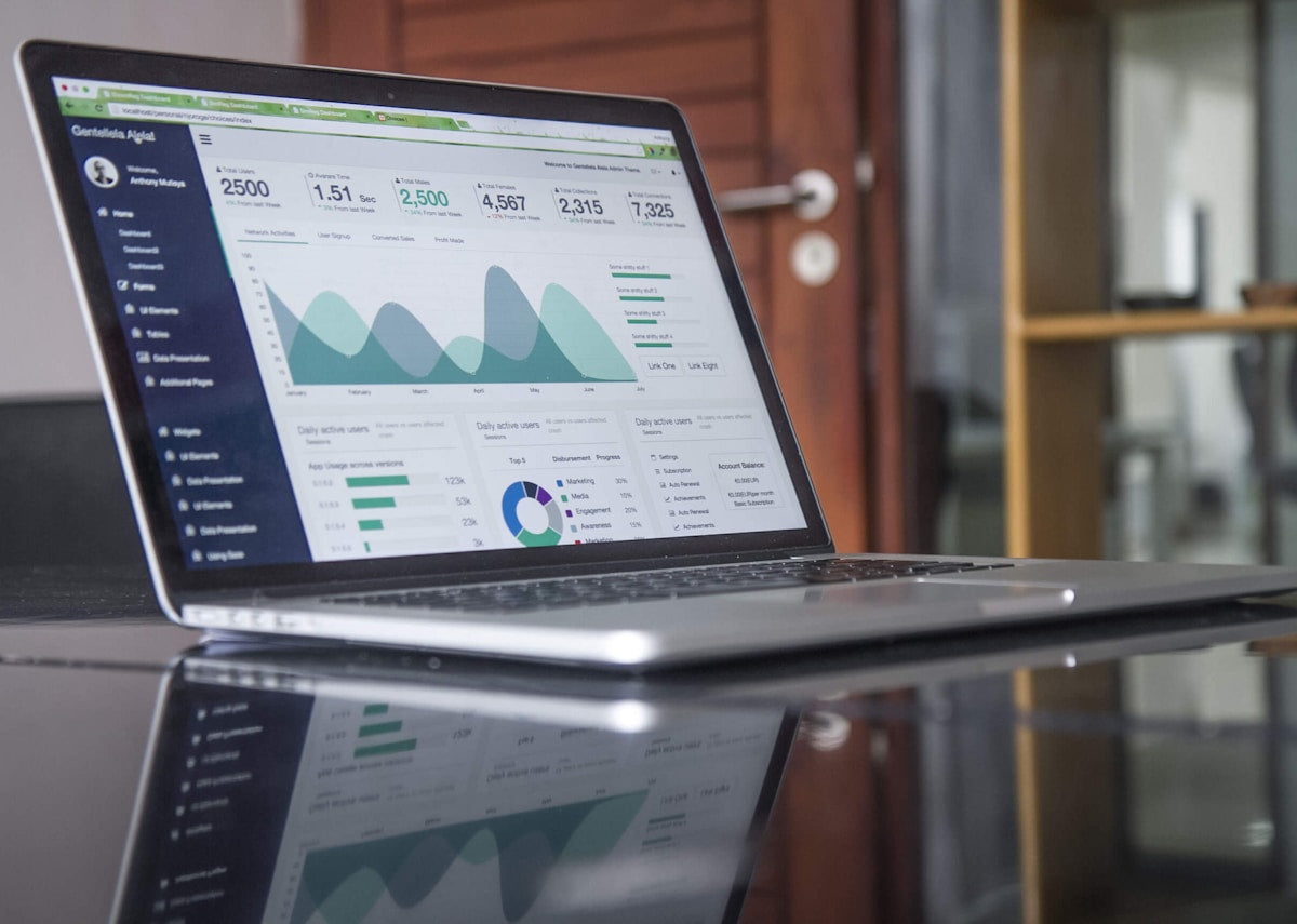 An analytics screen and laptop showing marketing performance